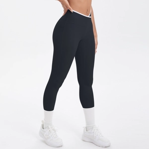 Détail du legging de yoga taille haute montrant la ceinture croisée en V noire et blanche