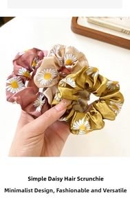 Detailed texture of satin daisy scrunchies in pink, beige, and yellow colors