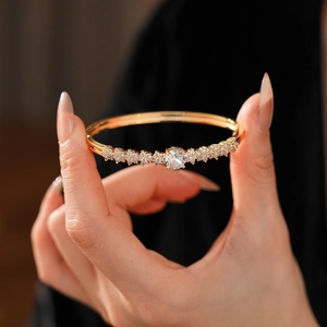 Macro detail of gold plated bracelet featuring zircon flowers and sparkling pavé crystals