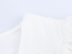 Détail des coutures et de la texture sur l'encolure d'une robe blanche française
