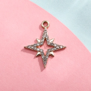 Detail of gold-plated snowflake pendant with white rhinestones on pastel background