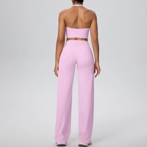 Detail view of the back of a pink halter sports bra and high-waisted wide-leg yoga pants