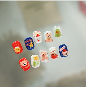 Close-up of 3D embossed Christmas bear nail art stickers with festive red and blue patterns