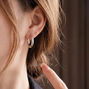 Minimalist silver hoop earrings with polished finish shown on a model for a chic look