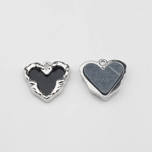 Detail of silver heart-shaped alloy pendants with black and blue textured enamel centers