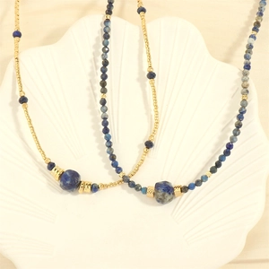 Detailed macro shot of irregular blue stone beads and gold metal spacers on jewelry