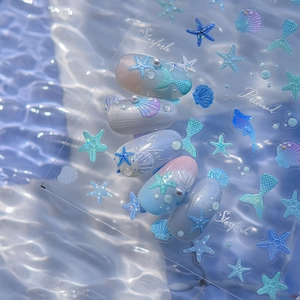 Détails macro des autocollants à ongles océan avec des motifs d'étoiles de mer bleues