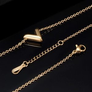 Macro shot of 18K gold plated V-shape charm with 18KGP engraving on the clasp tag