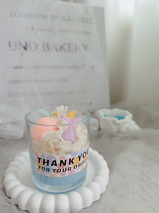Detail of blue strawberry cup candle with sea shells and mermaid tail wax decorations