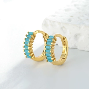 Détail macro de créoles en argent S925 doré avec incrustation de pierres turquoise