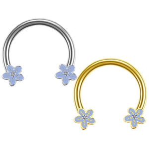 Close-up of gold and silver horseshoe rings with blue flower ends and small crystals