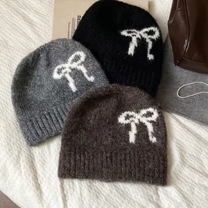 Three Korean-style knit beanie hats in black, grey, and brown with white bow patterns