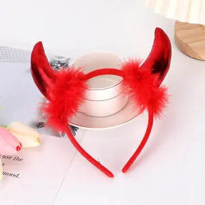 Detail of red devil horns headband with soft feathers and metallic texture for Halloween party