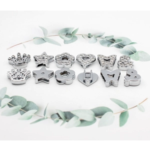 Flat lay of chrome-plated alloy slider beads with star and crown shapes for DIY crafts