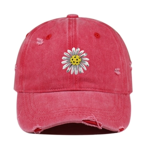 Detailed view of a vintage red distressed baseball cap with soccer daisy embroidery