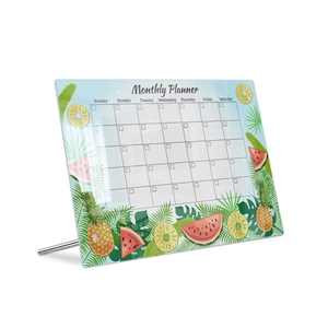 Macro shot of an acrylic monthly planner with tropical fruit motifs and metal stand