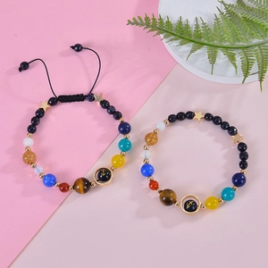 Detail of beaded solar system bracelets with natural stones and gold star charms