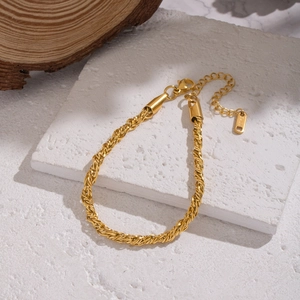 Bracelet chaîne torsadée dorée en acier inoxydable étanche sur un support en pierre