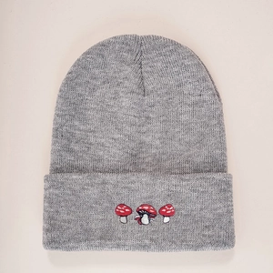 Grey knit beanie featuring three red and white mushroom embroidery details on folded brim
