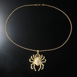 Macro shot of hip hop spider pendant with crystal rhinestones on gold rope chain