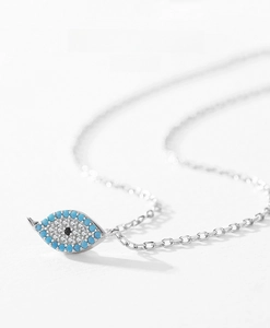 Macro detail of S925 silver Evil Eye pendant with turquoise and sparkling cubic zirconia