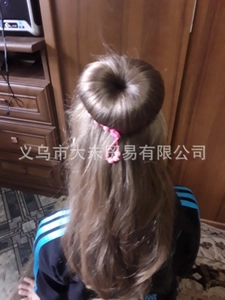 Close-up of children light brown hair bun donut with pink beaded hair accessory detail