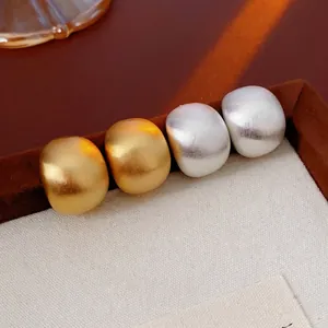 Minimalist matte brushed metal stud earrings in gold and silver finish set in a jewelry box