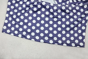 Detail of purple polka dot fabric showing texture and reinforced double-stitching
