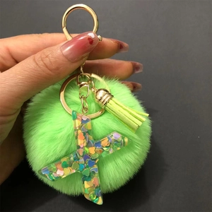 Star-shaped resin keychain with green pom pom, tassel and colorful heart sequins
