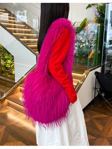 Close-up of fluffy rose red faux fur shoulder bag with soft plush texture and long fringe