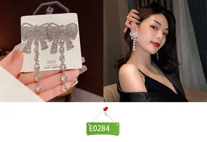 Silver bow knot earrings with dangling crystal tassels and S925 needles on female model