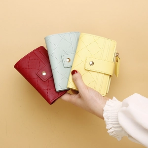 Detail van korte gewatteerde portemonnees in rood, blauw en geel met ruitvormig stiksel