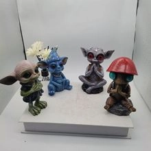 Detailed view of assorted miniature alien resin sculptures on a book for home decor