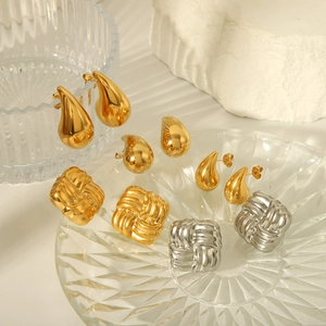 Boucles d'oreilles chic dorées en goutte d'eau et carrées texturées sur pierre
