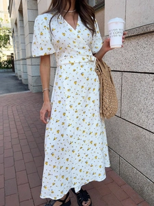 Detail of V-neck floral cotton dress with yellow flower print and waist tie-up