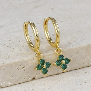 Close-up of S925 sterling silver gold earrings with green four-leaf clover zircon charms
