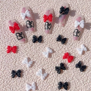 Detailed view of resin 3D bow nail art charms with heart pattern press-on nails