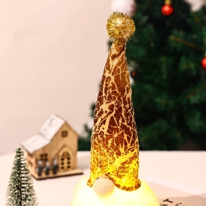 Close-up of glowing Christmas forest gnome with golden hat and warm LED light base