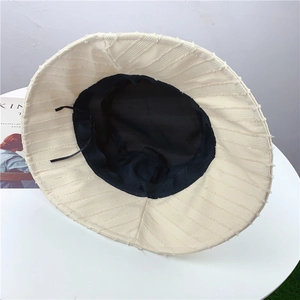Détail du chapeau bob rayé montrant le cordon de réglage interne et la doublure