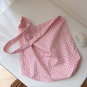 Détail du sac cabas en coton avec motifs nœuds rouges et large bandoulière