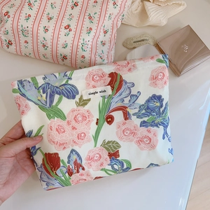 Détail d'une trousse à maquillage en coton avec imprimé floral et étiquette simple wish