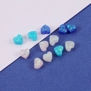 Macro shot of heart-shaped synthetic opal resin beads with holographic flakes in mixed colors