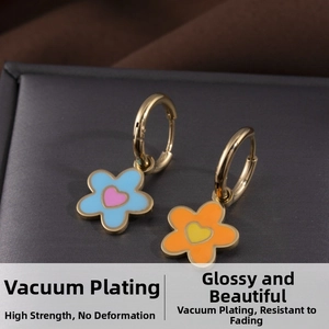 Détail de boucles d'oreilles fleurs colorées avec cœurs et anneaux dorés à l'or