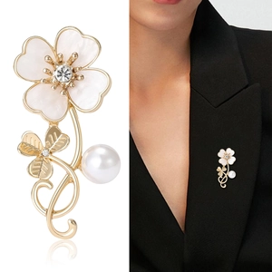 Elegant clover shell flower brooch with crystal and pearl details on a black suit lapel