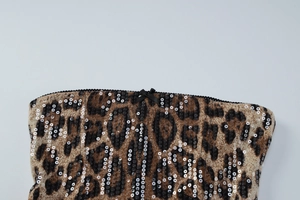 Détail du tissu léopard avec paillettes et petit nœud noir au niveau de l'encolure