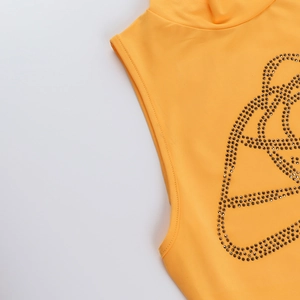 Détail d'un haut orange sans manches à col montant avec motifs floraux en strass