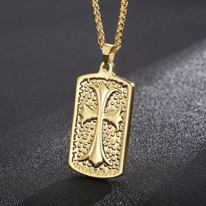 Detail of gold rectangular pendant with cross pattern and hammer texture on rope chain