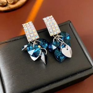 Macro detail of luxury heart fringe earrings with blue crystal hearts and AB rhinestones