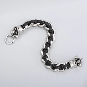 Macro detail of men's punk skull braided stainless steel bracelet with silver and black leather