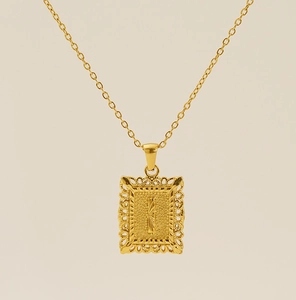 Gros plan du pendentif rectangulaire ajouré en or 18 carats avec la lettre I texturée